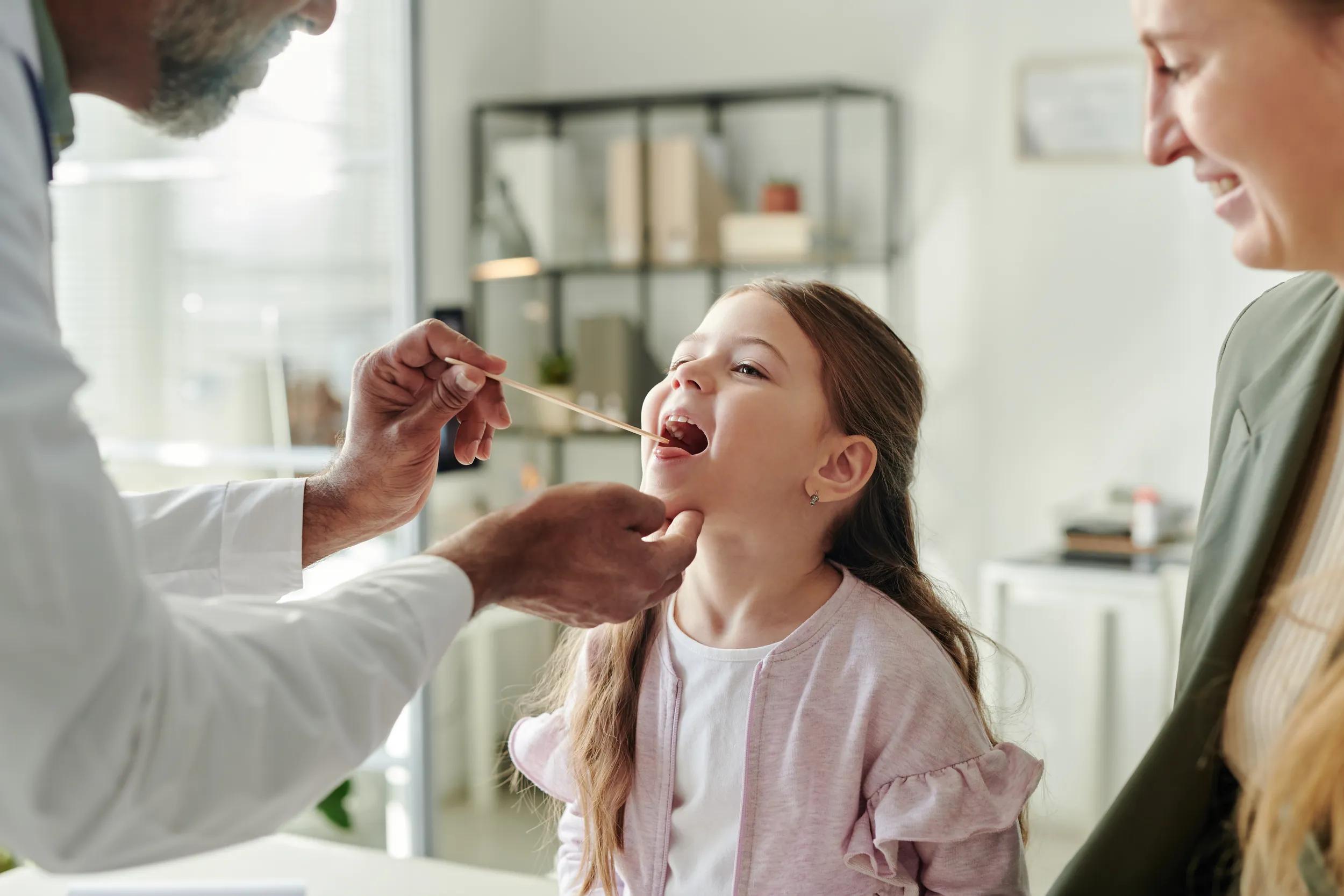 Little girl having her throat checked