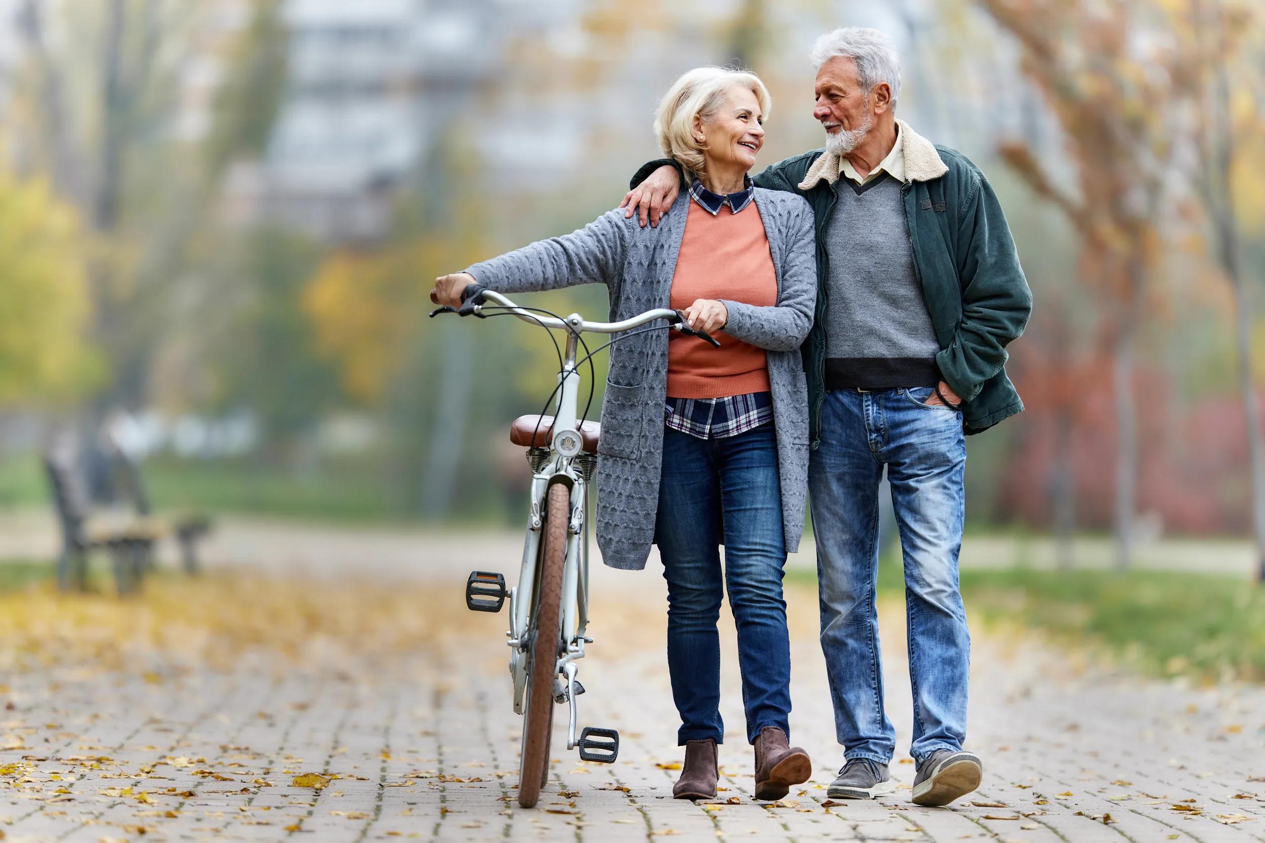 Happy senior couple enjoying in autumn walk at the park.