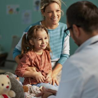Smiling girl having an appointment with her mother at pediatricians
