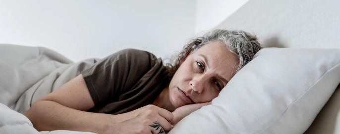 Depressed woman lying in her bed