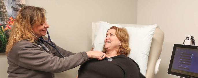 Nurse checking patients heart rate heart beat using a stethoscope