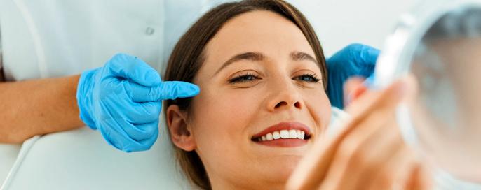 Beautiful Woman on Facial Treatment looking at mirror