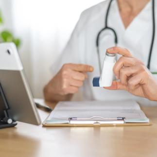 Allergist doctor pointing at an asthma inhaler during a consultation, discussing treatment options and explaining proper corticosteroid usage for respiratory disease management