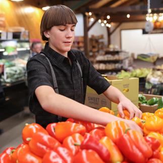 Grocer stocking produce
