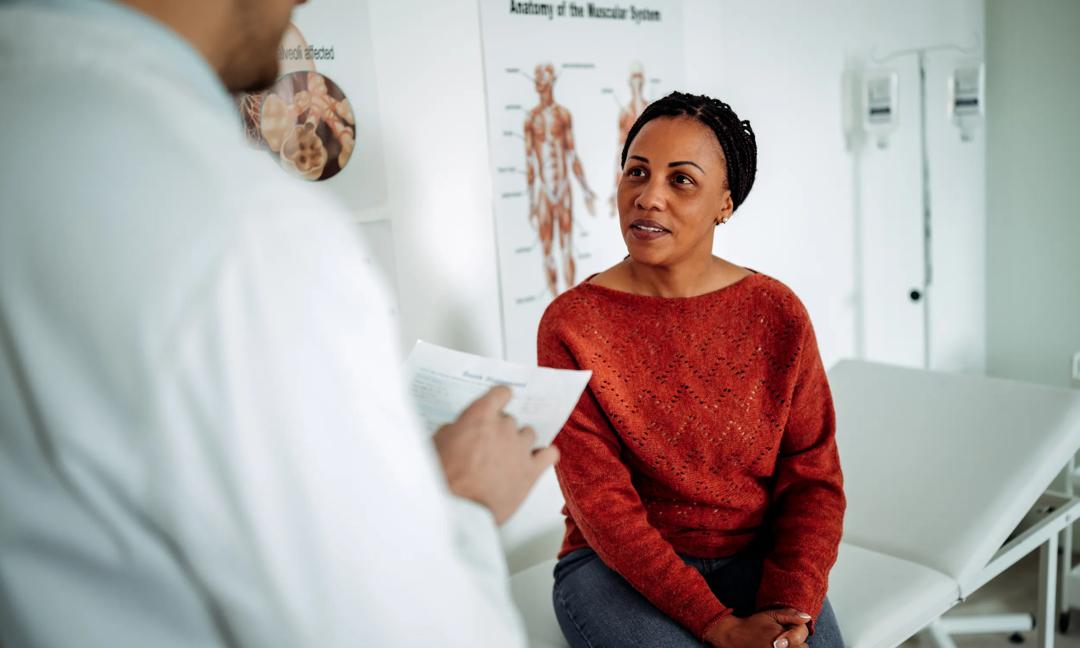 Male doctor consulting with female patient