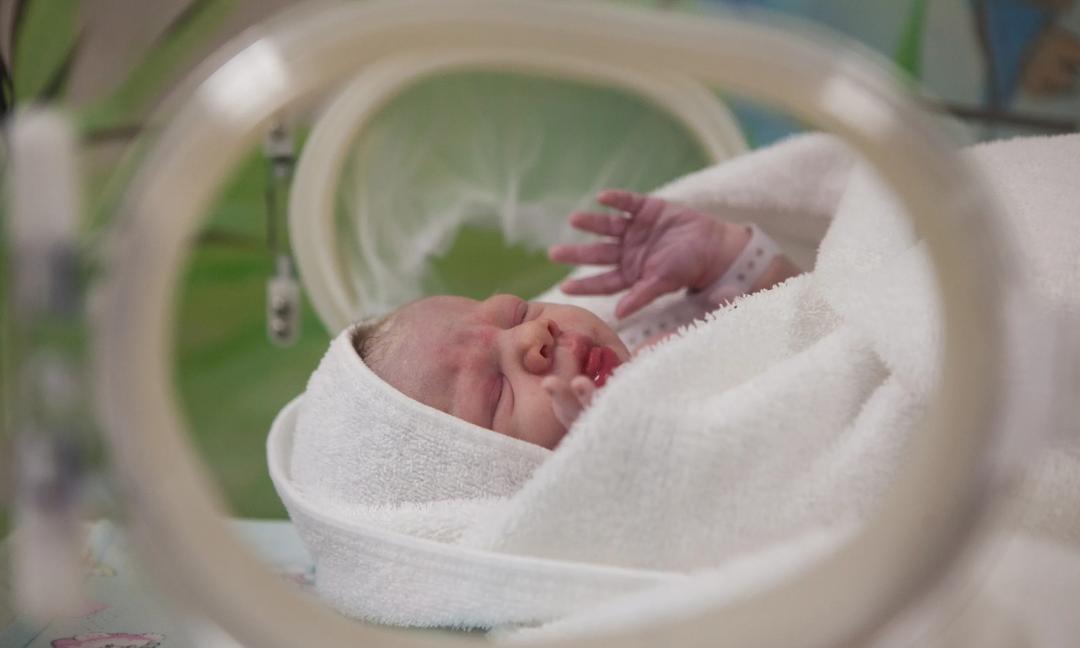 Newborn baby lying in her cot just after delivery