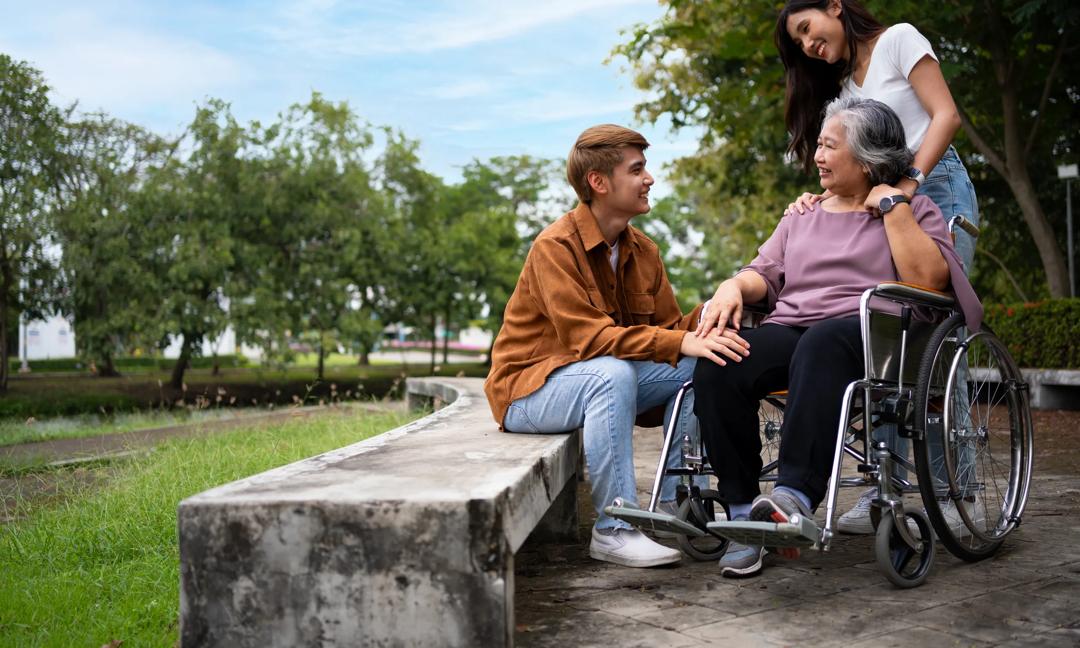 Asian careful caregiver or nurse taking care of the patient in a wheelchair.  Concept of a happy retirement with care from a caregiver and Savings and senior health insurance, a Happy Family