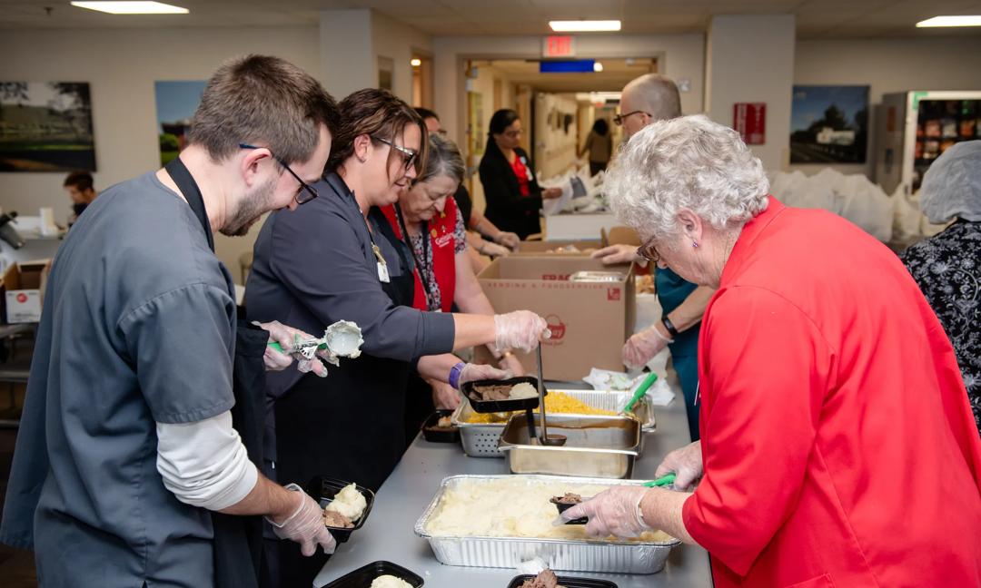 Photos of leadership, staff and volunteers handing out meals at Veteran appreciation dinner