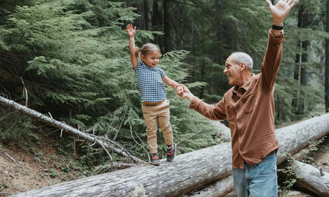 Joyful little girl enjoying nature with her playful grandfather
