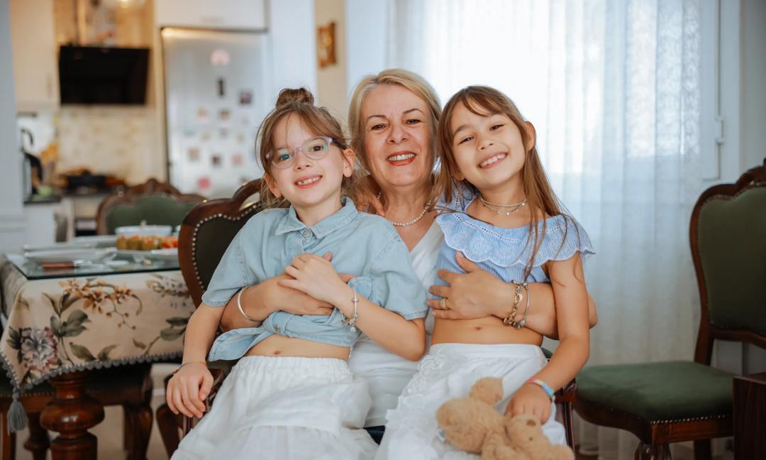Grandmother, childs hug in a portrait for mothers day on a house sofa as a happy family. Smile, elderly woman love hugging young girl or kids and enjoying quality time
