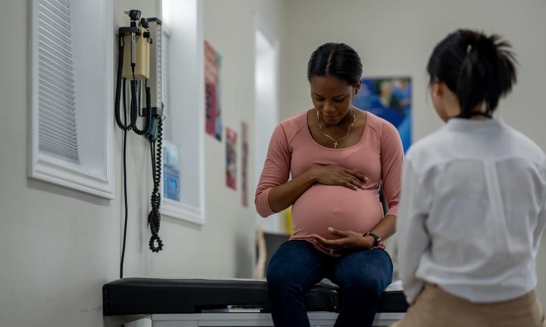 Pregnant Woman Consulting Doctor in Medical Clinic for Prenatal Checkup