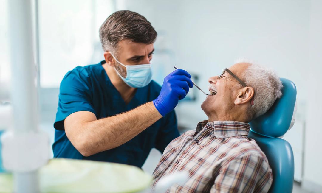 Young dentist giving his senior patient a routine checkup