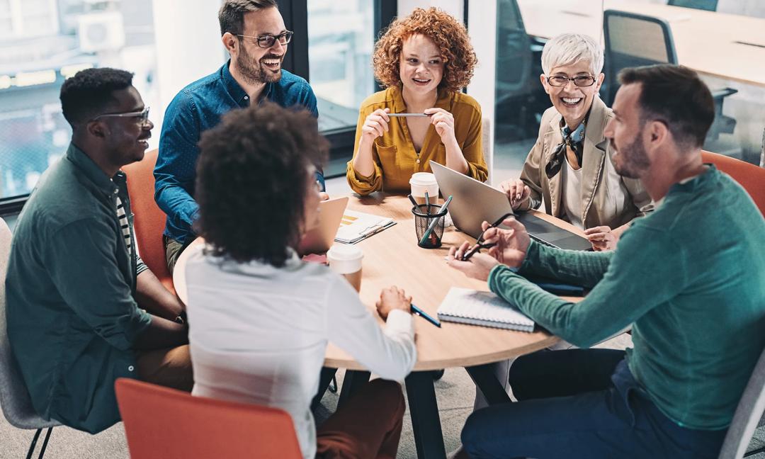 Mixed group of business people sitting around a table and talking