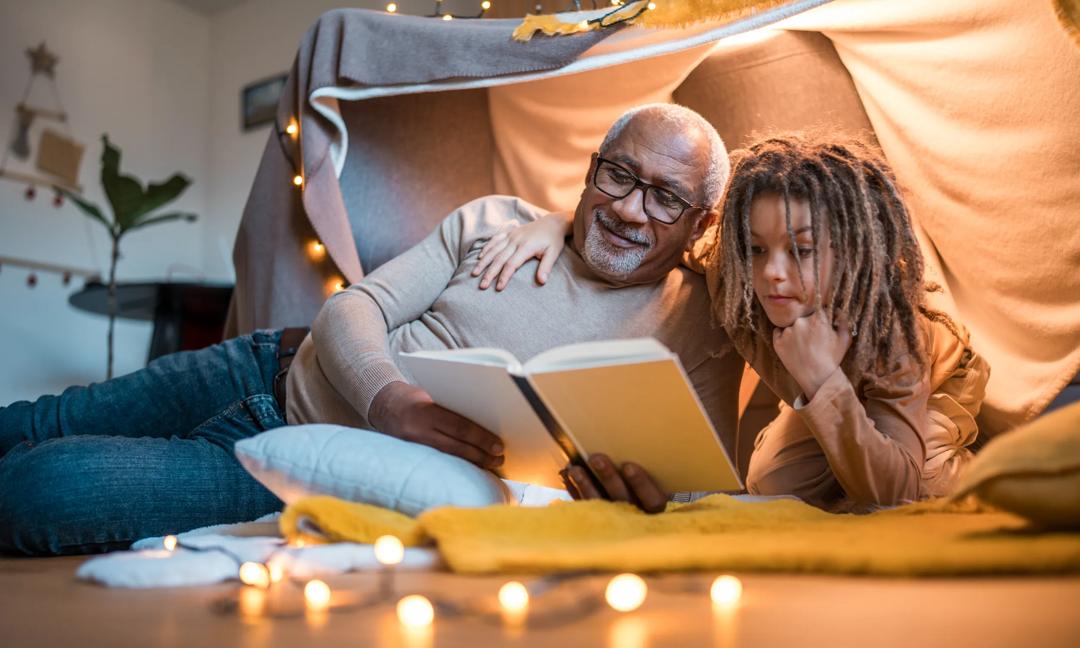 Grandfather and Grandosn Reading Together in Cozy Indoor Fort