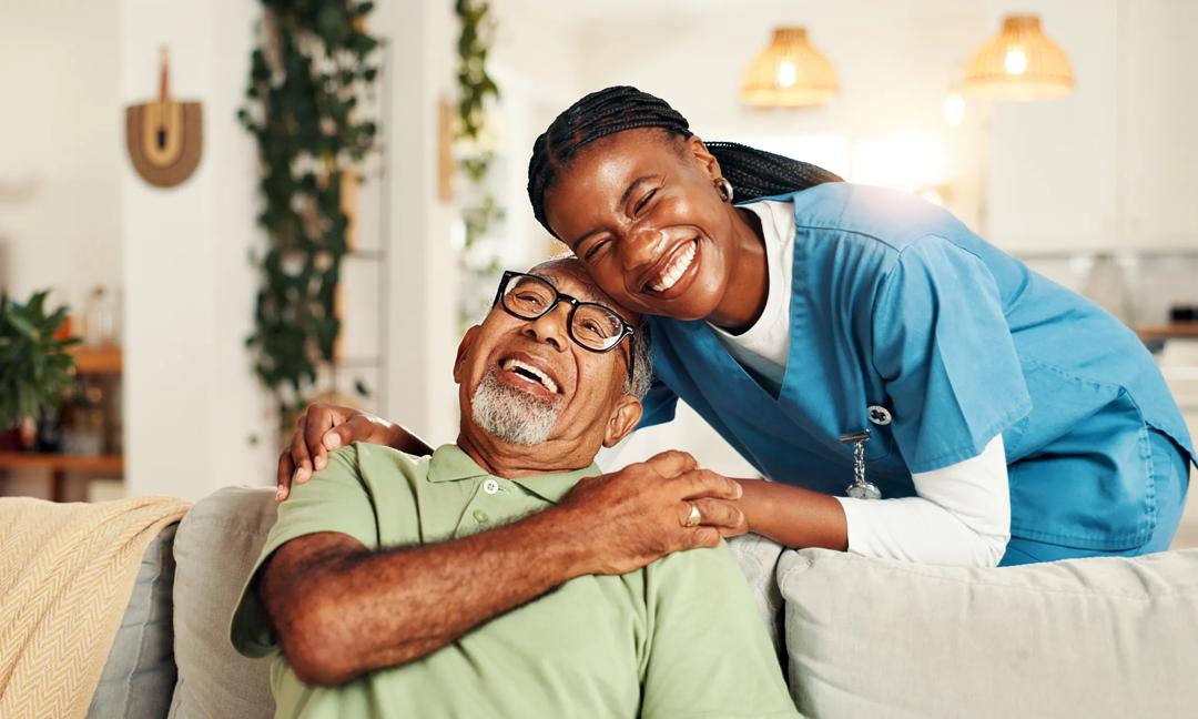 Hugging, happy and nurse with senior man for comfort, support or care for good news. Portrait, consultation and caregiver embracing elderly male patient on sofa in living room at nursing home.