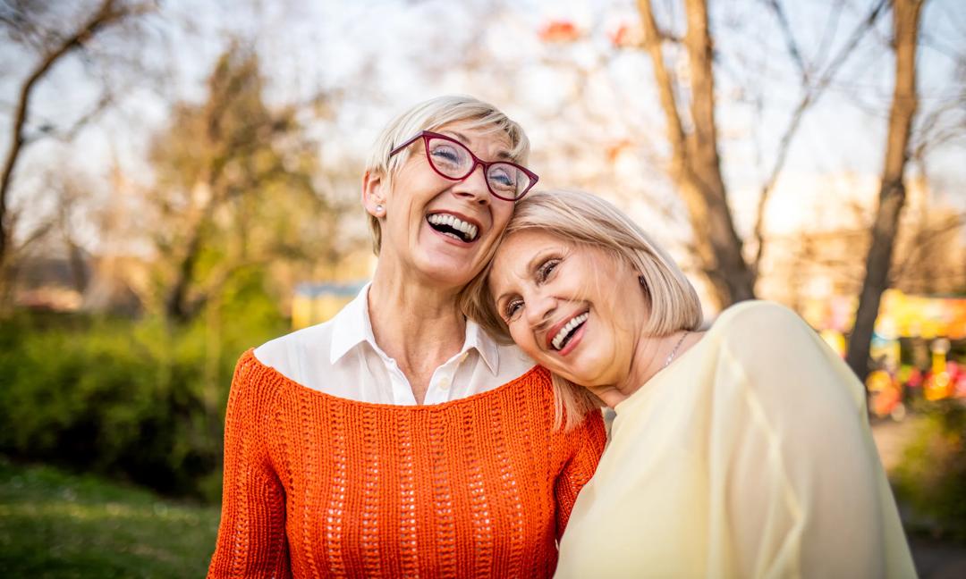 Two senior women laughing at the park