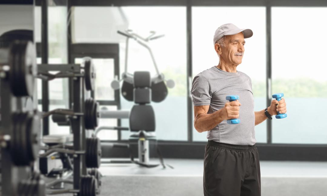 Senior man lifting light dumbbells during a workout