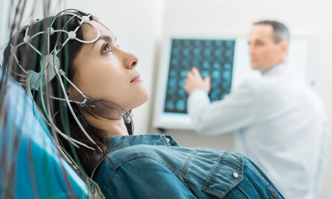 Charming young woman undergoing electroencephalography