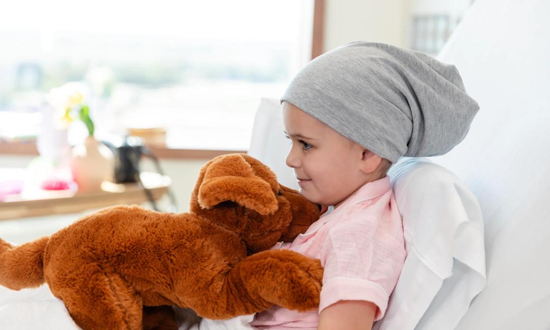 Little girl with cancer lies in hospital bed