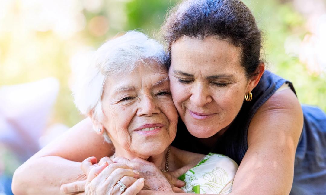 Happy Smiling mature woman posing hugging with her senior mother