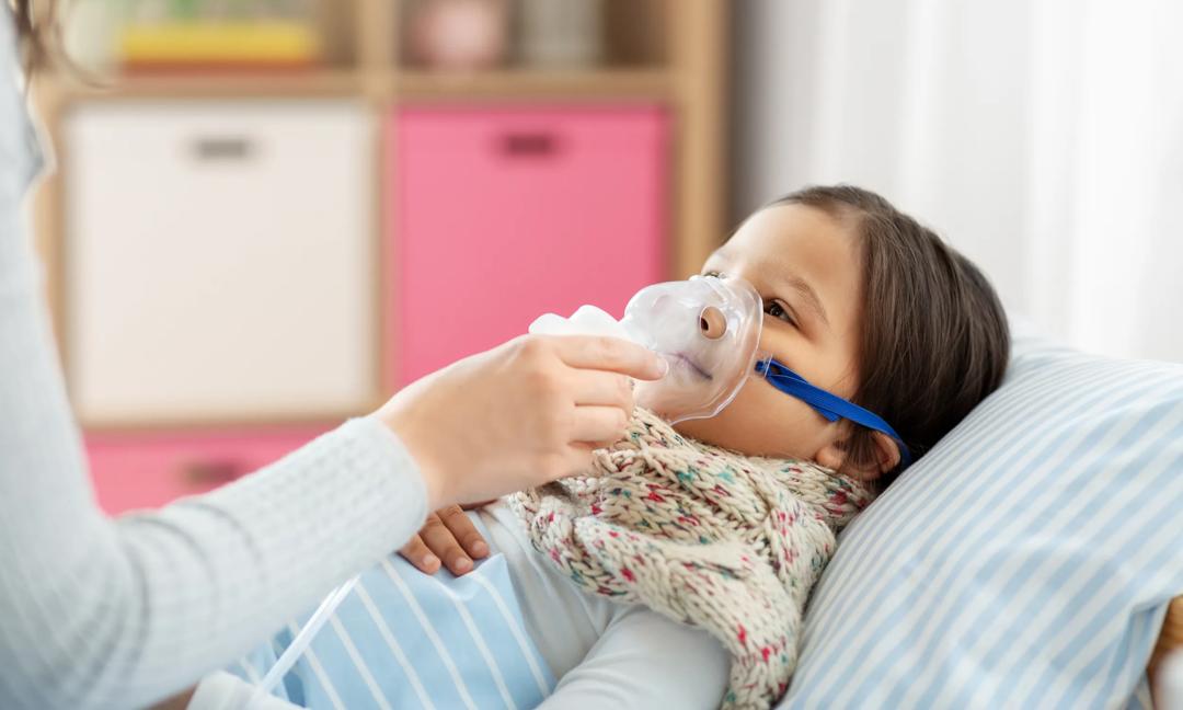 mother and sick daughter with oxygen mask in bed