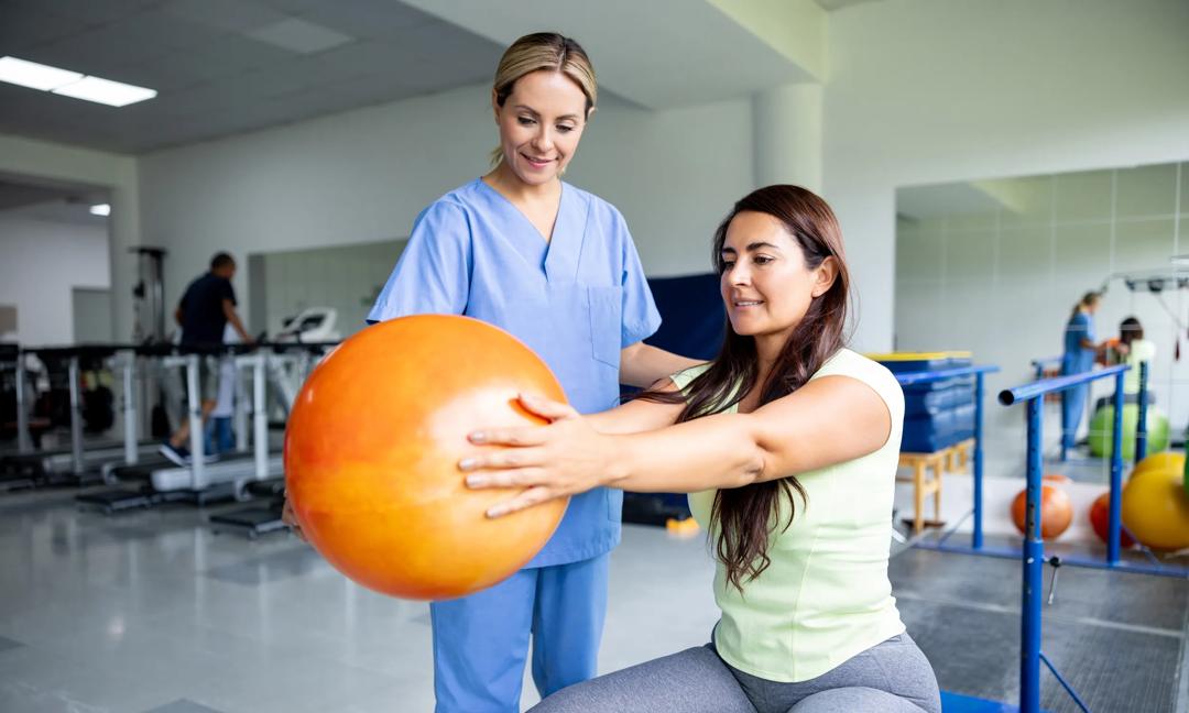 Woman doing physical therapy exercises using a fitness ball