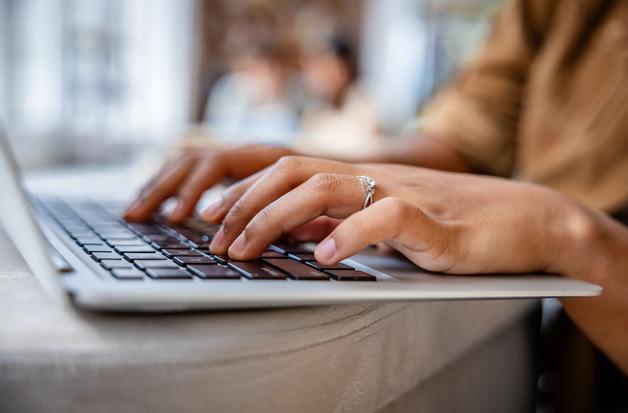Student Typing on Laptop in Modern Study Environment with Soft Lighting