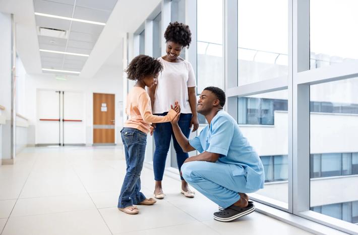 Happy girl giving a high-five to a nurse at the hospital