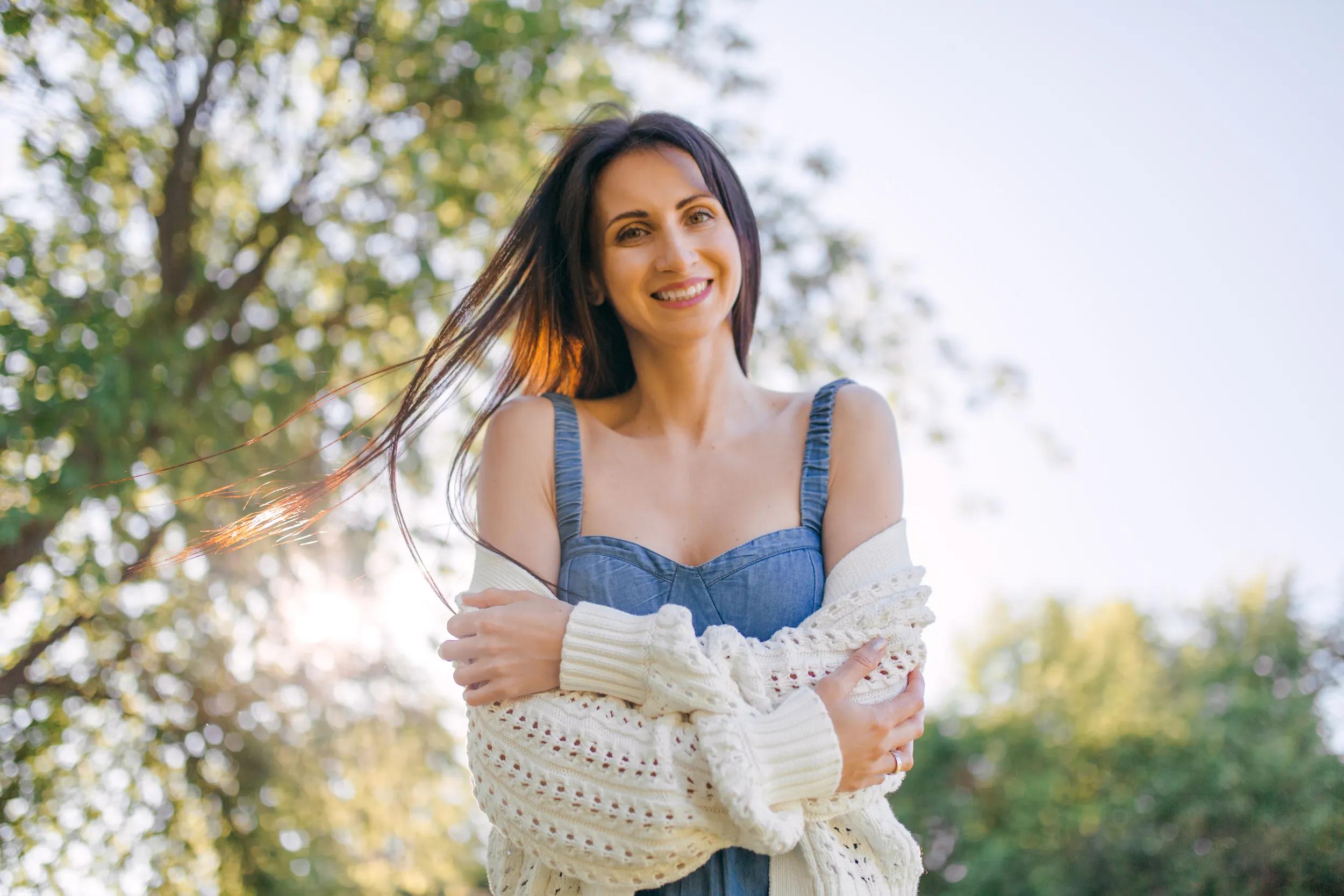 A young pretty girl enjoys nature. Sunny summer day outdoors, vacation, relax, life balance